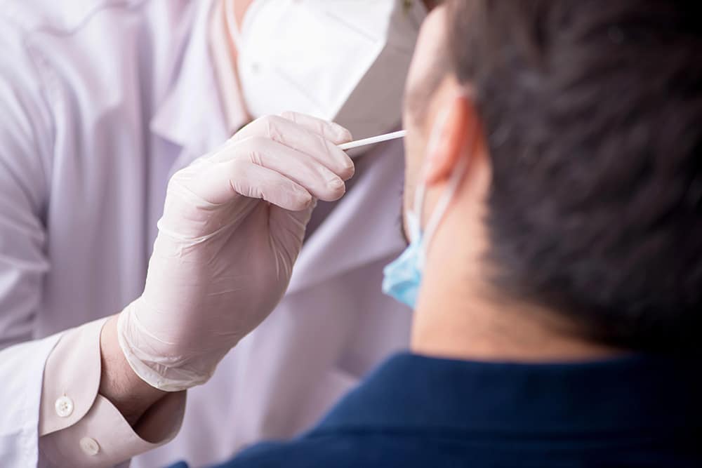 Oral Fluid Drug Testing - a collector taking an oral swab